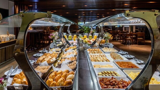 A buffet with various food items and a seating area in the background. - Paradiso Corporate - Cabo Frio (Cabo Frio)