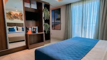 Ein Hotelzimmer mit Bett, einem großen Spiegel, einem Fernseher, einer Pflanze und Blick nach außen.