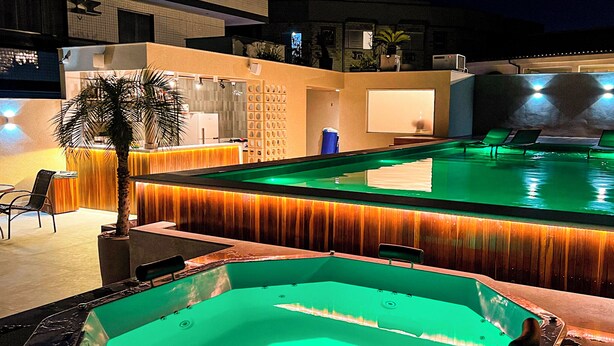 Un área de piscina con jacuzzi y sillas de descanso.