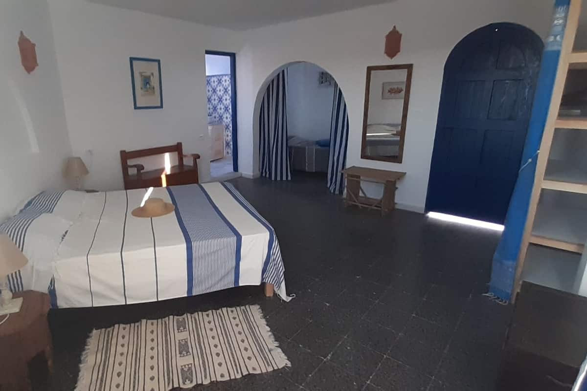A bedroom with a bed, a desk, a chair, and a wardrobe.