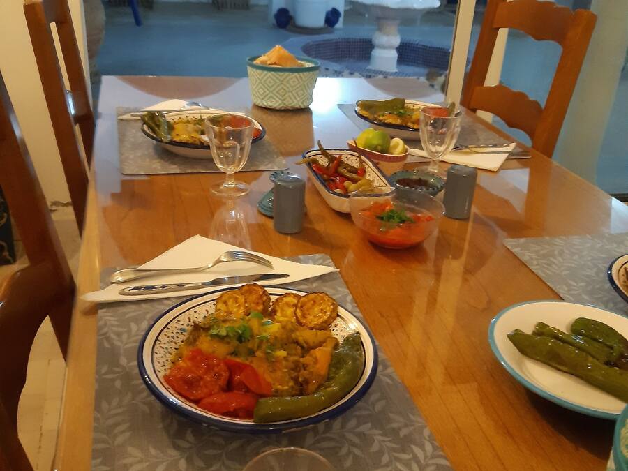 A dining table set with various dishes, glasses, and a salt and pepper shaker.