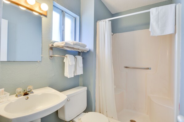 Un baño con lavamanos, inodoro y cortina de ducha.