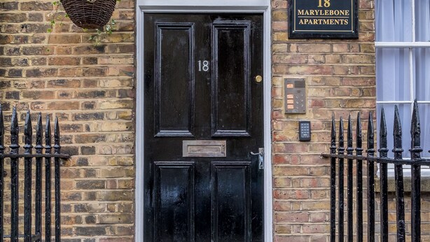 A black double door with a number plate reading "18 Marylebone Apartments" on a brick wall. - Marylebone Apartments (London)