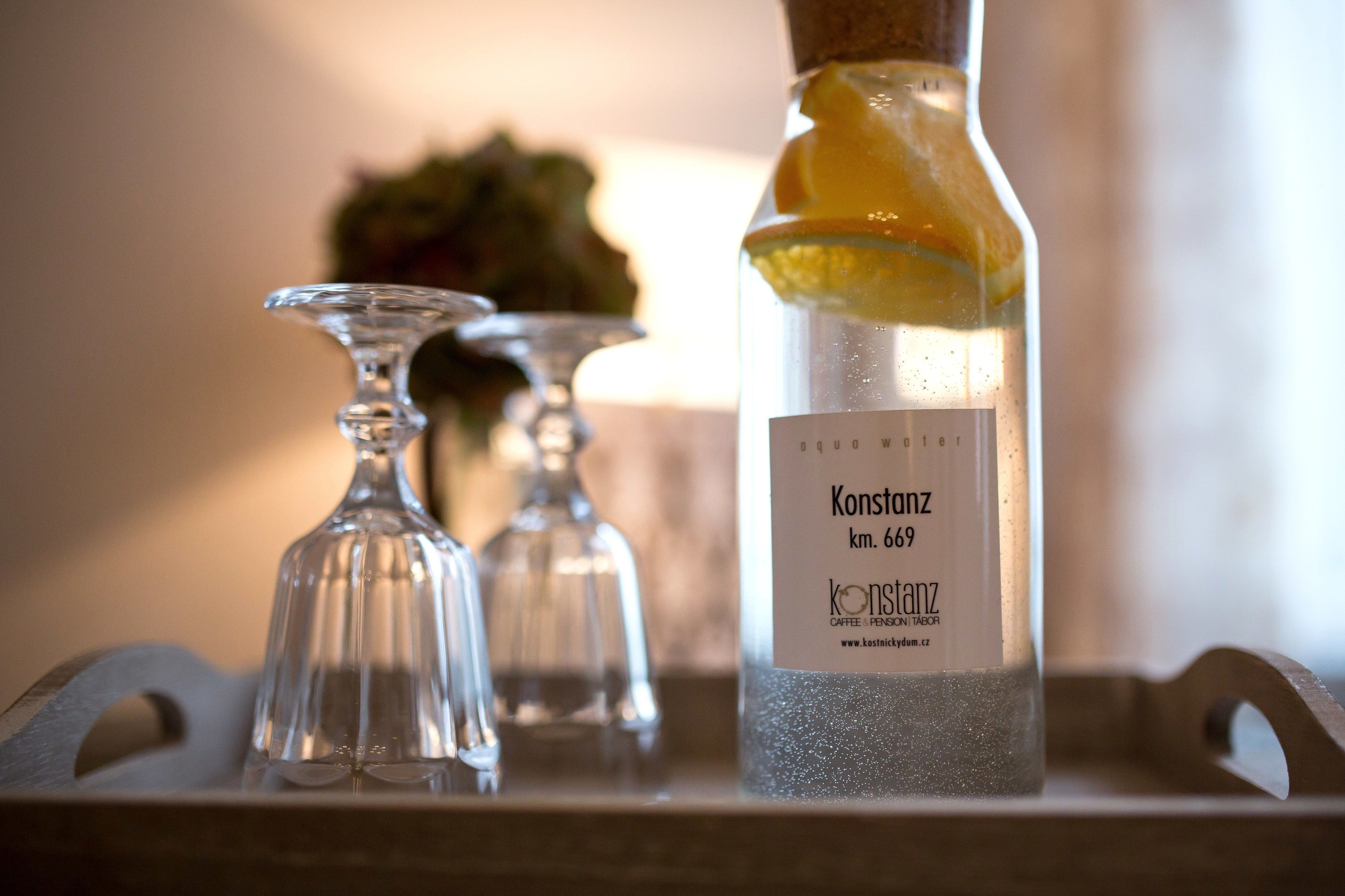 Una botella de vino Konstanz con corcho y etiqueta, sobre una bandeja con dos copas.