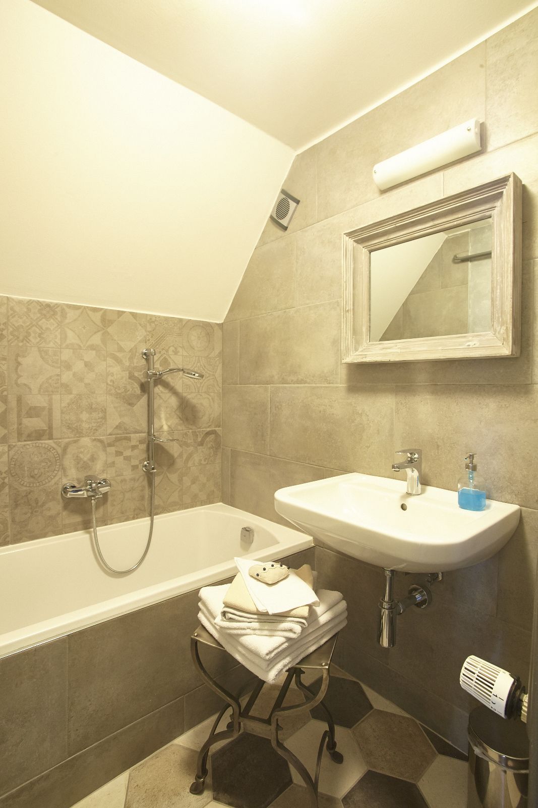 A bathroom with a bathtub, a sink, and a mirror.