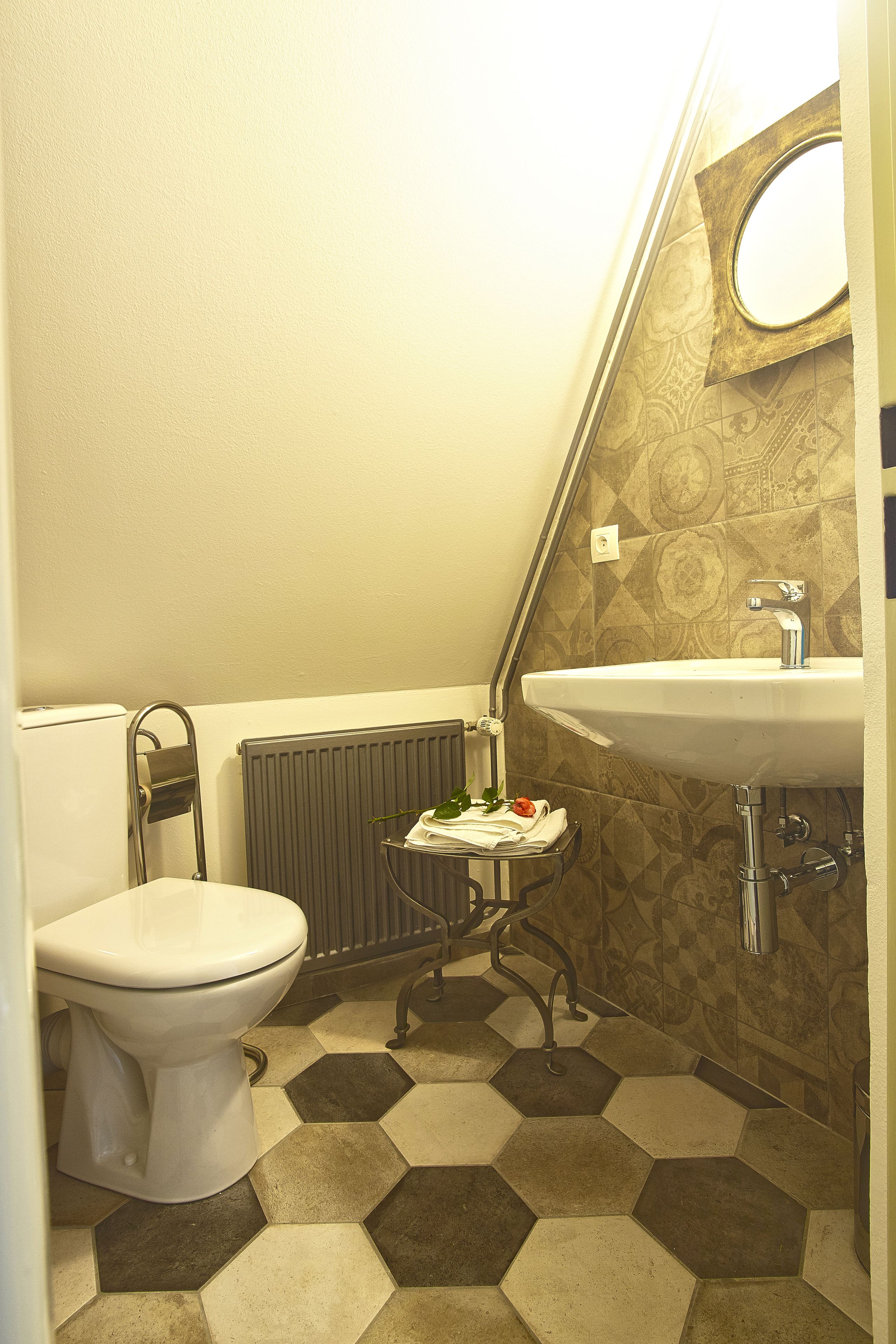 A small bathroom with a toilet, a sink, and a radiator.