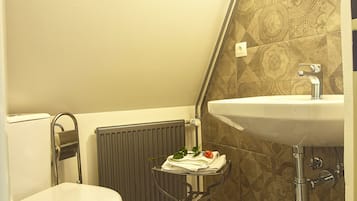 A small bathroom with a toilet, a sink, and a radiator.