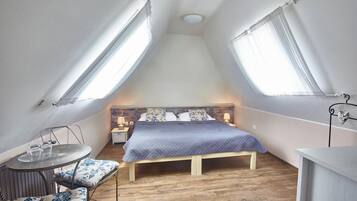 Une petite chambre à coucher, chaleureuse et accueillante, avec un lit, des tables de chevet et une chaise.