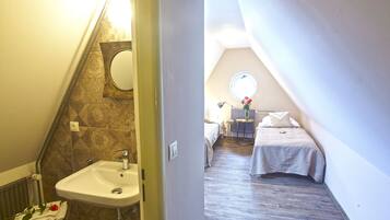 A bedroom with a bed, a small table, and a nightstand.
