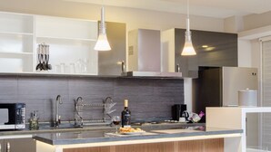 Una cucina moderna con forno a microonde integrato, una bottiglia di vino e una macchina per il caffè.