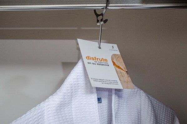 A white towel hanging on a metal rack with a tag attached to it.