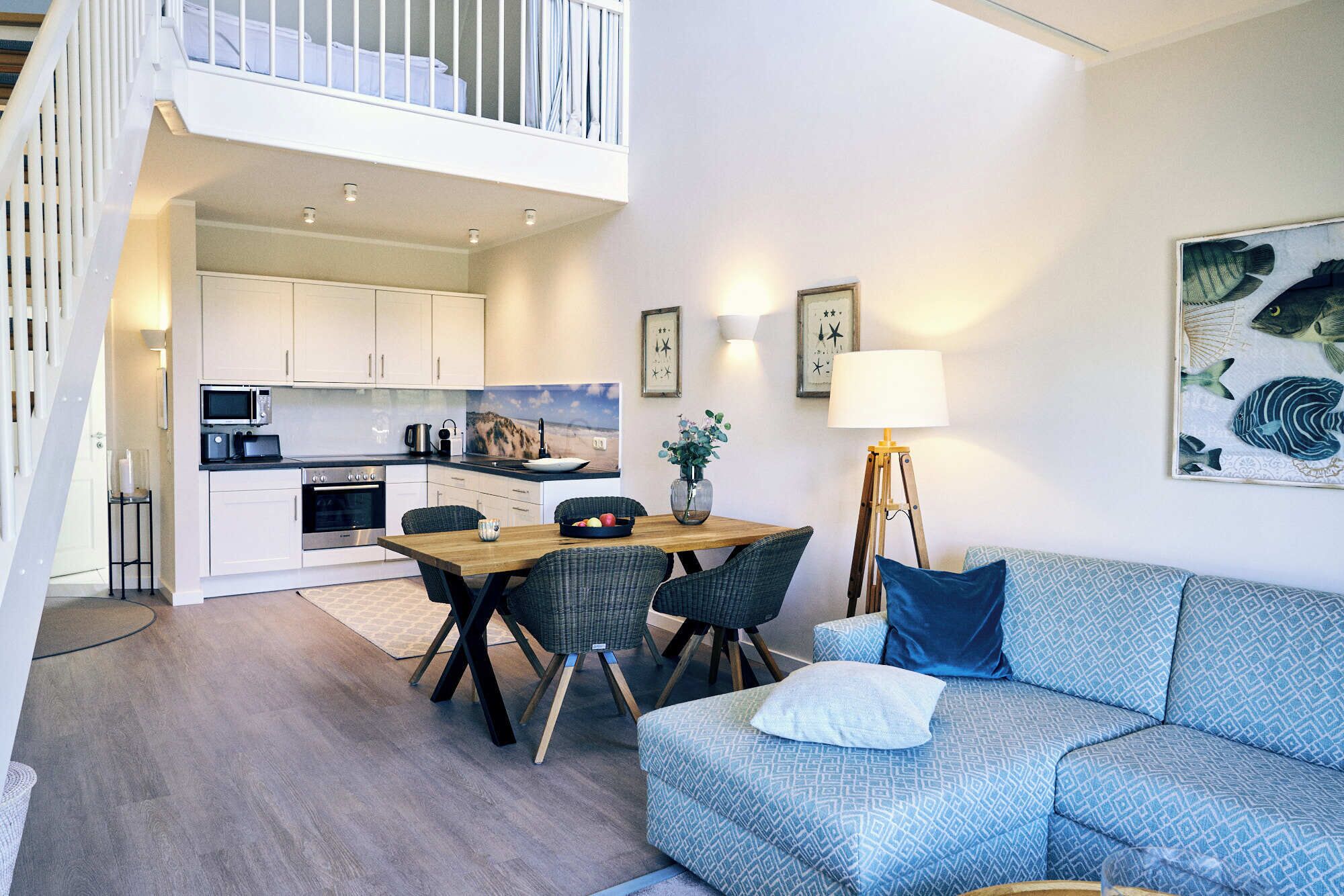 Un appartement moderne comprenant un coin repas, une cuisine et un salon avec un canapé et une lampe.