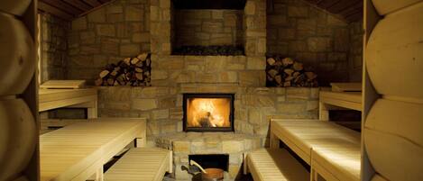 A stone fireplace with benches around it.