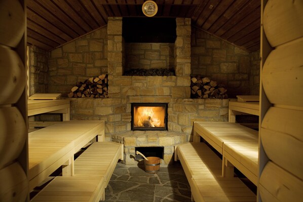 A stone fireplace with benches around it. - Ferienwohnungen Dünenmeer (Ostseebad Dierhagen)