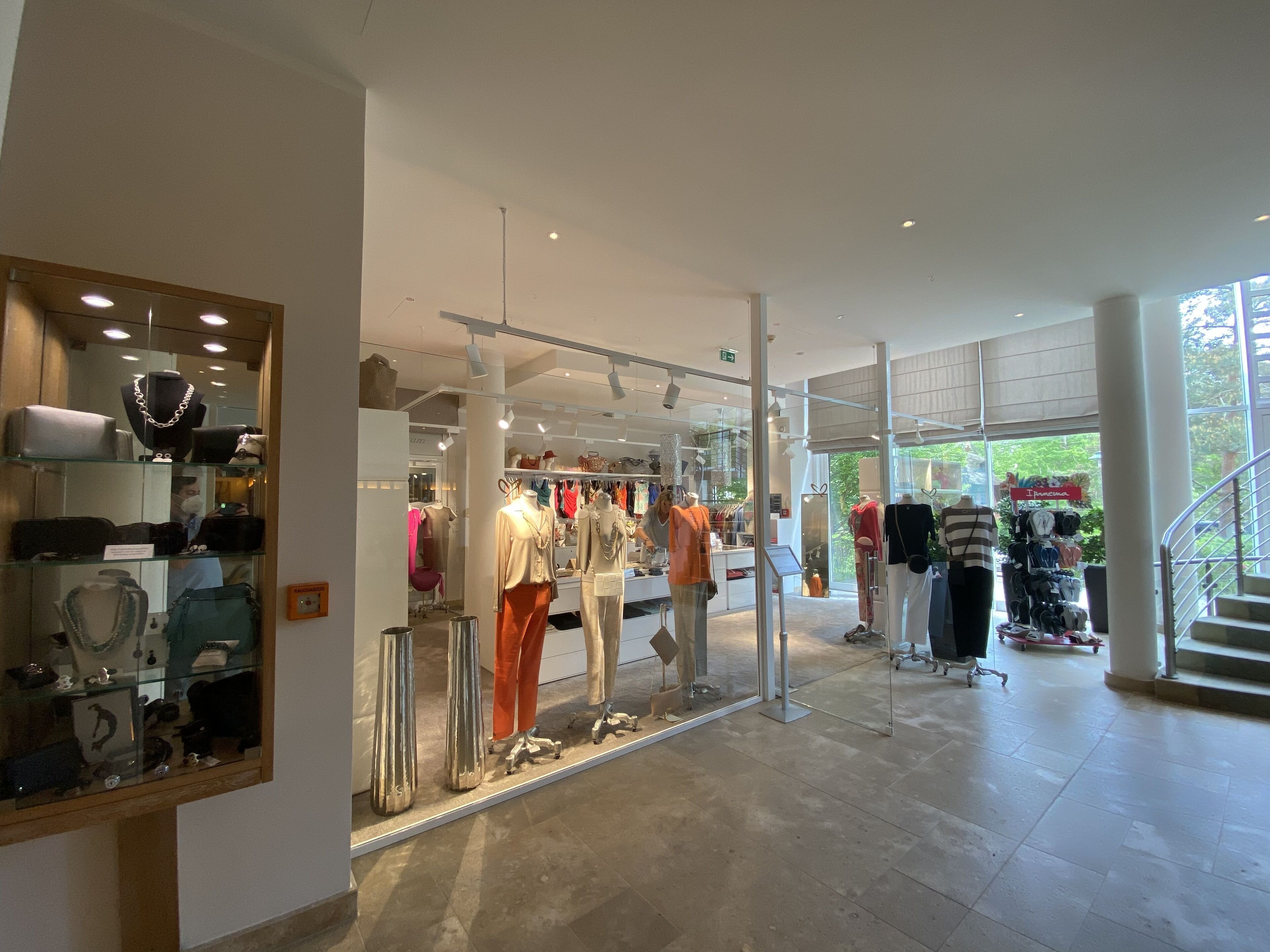 A modern retail store with glass display cases and mannequins.
