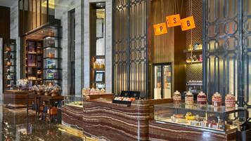 A modern interior with a marble counter, glass display cases, and a decorative wall with hanging letters.
