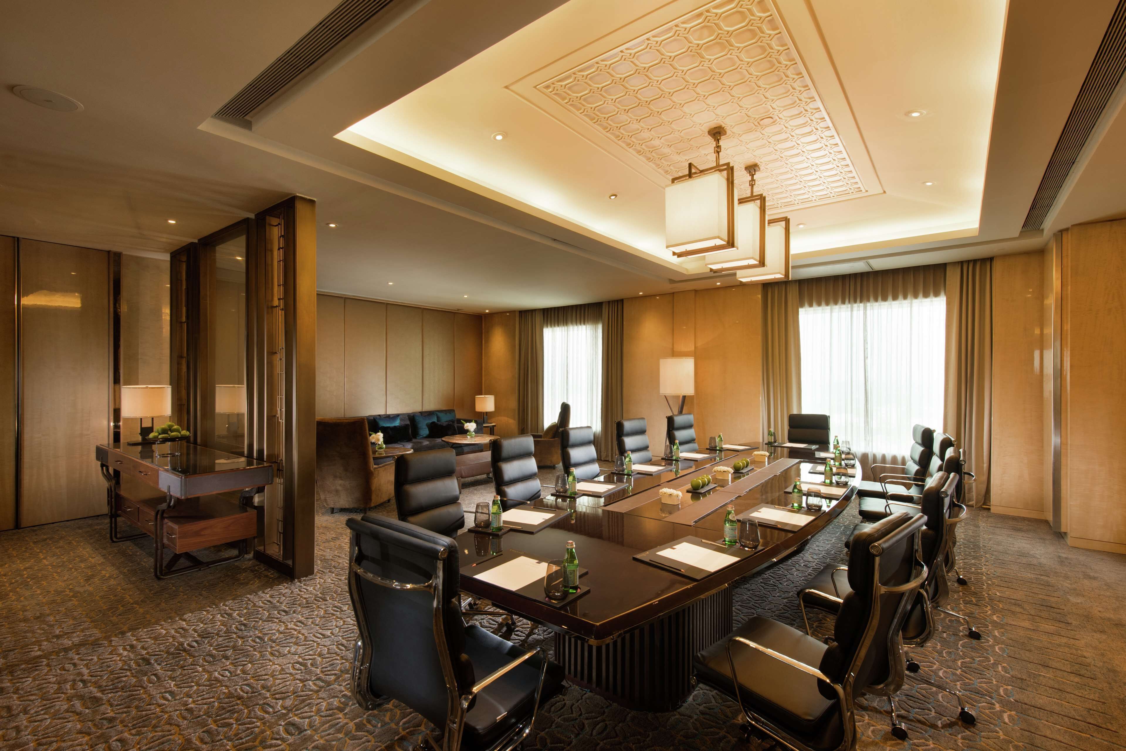 A conference room with a long table, multiple chairs, and a sofa.
