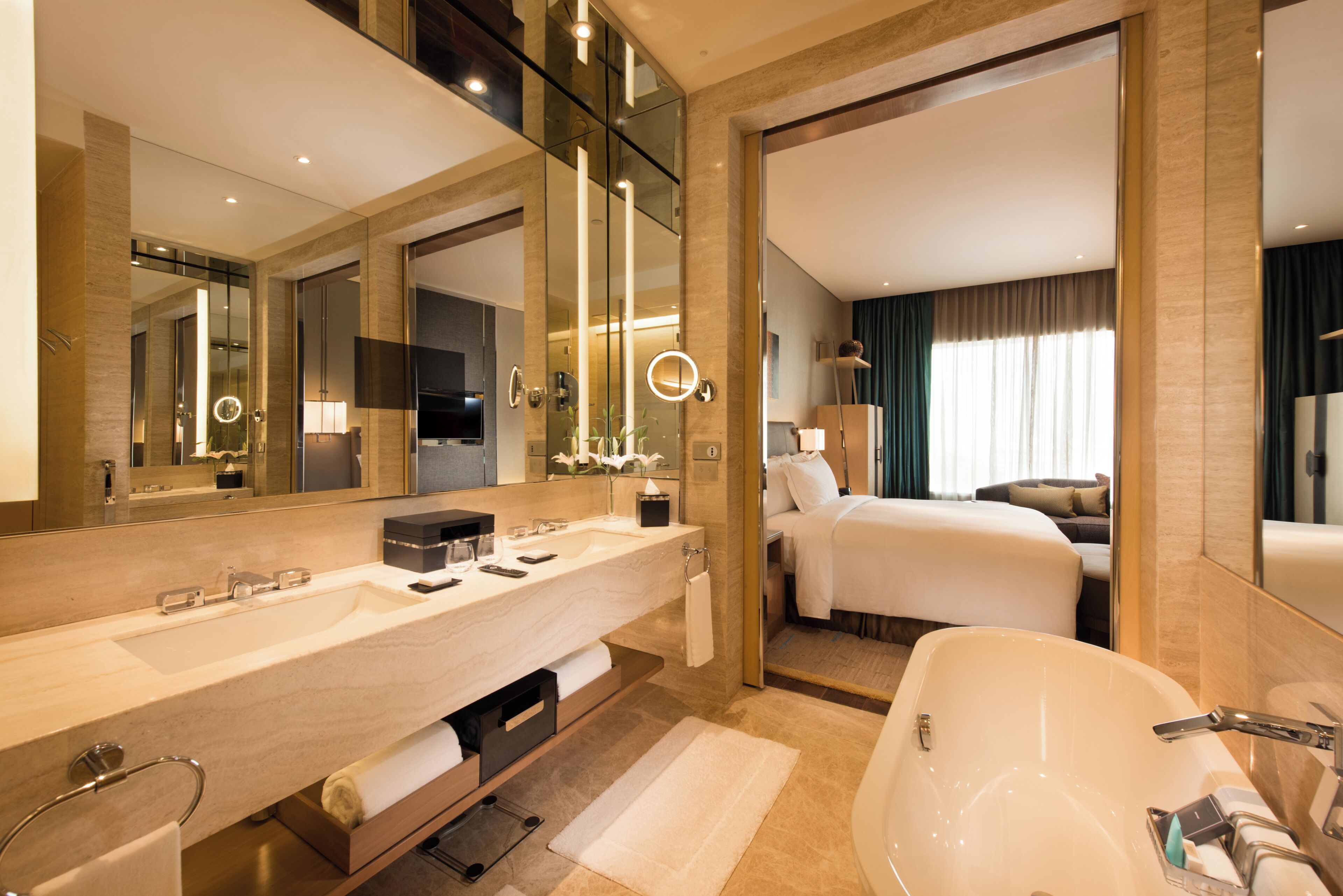 A modern hotel bathroom with a large sink, a bathtub, and a separate shower area.