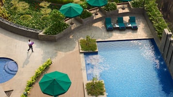 Una piscina al aire libre, camas de piscina gratis, sombrillas