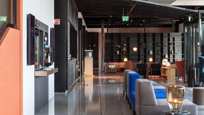 A modern lobby with a reception desk, seating area, and a glass display case. - Quality Hotel Pond (Sandnes)