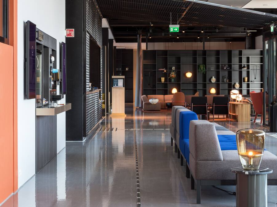 A modern lobby with a reception desk, seating area, and a glass display case.