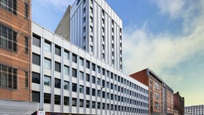 Un edificio moderno con una torre angular destacada y una serie de ventanas.