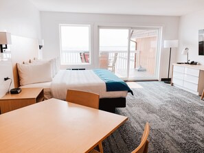 A hotel room with a bed, a desk, a chair, a dresser, and a TV. - La Place Rendez-Vous (Fort Frances)