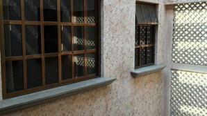 Un edificio con varias ventanas, algunas con rejas metálicas y otras con marcos de madera.