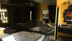 Un baño con dos tinas grandes, un espejo y un lavamanos.