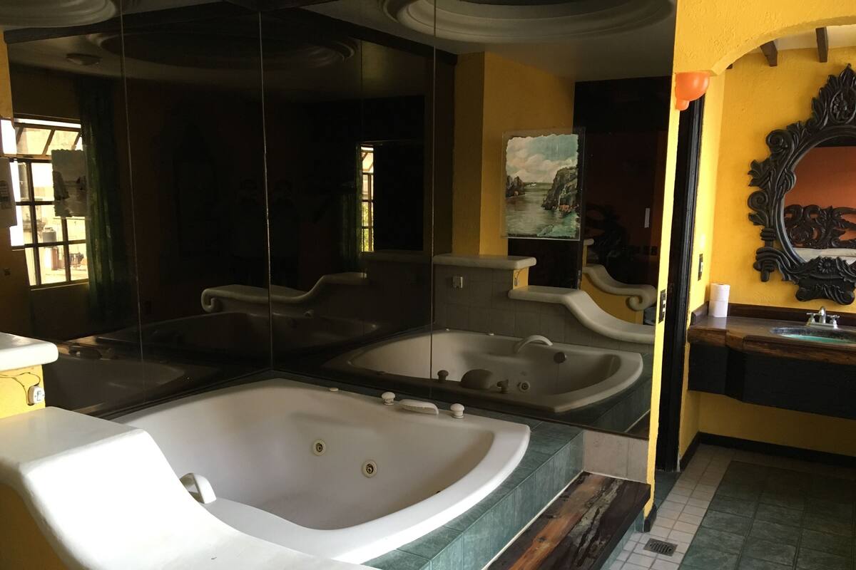 A bathroom with two large tubs, a mirror, and a sink.