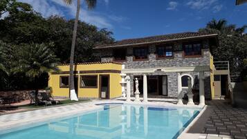 Een buitenzwembad, parasols bij het zwembad en ligstoelen