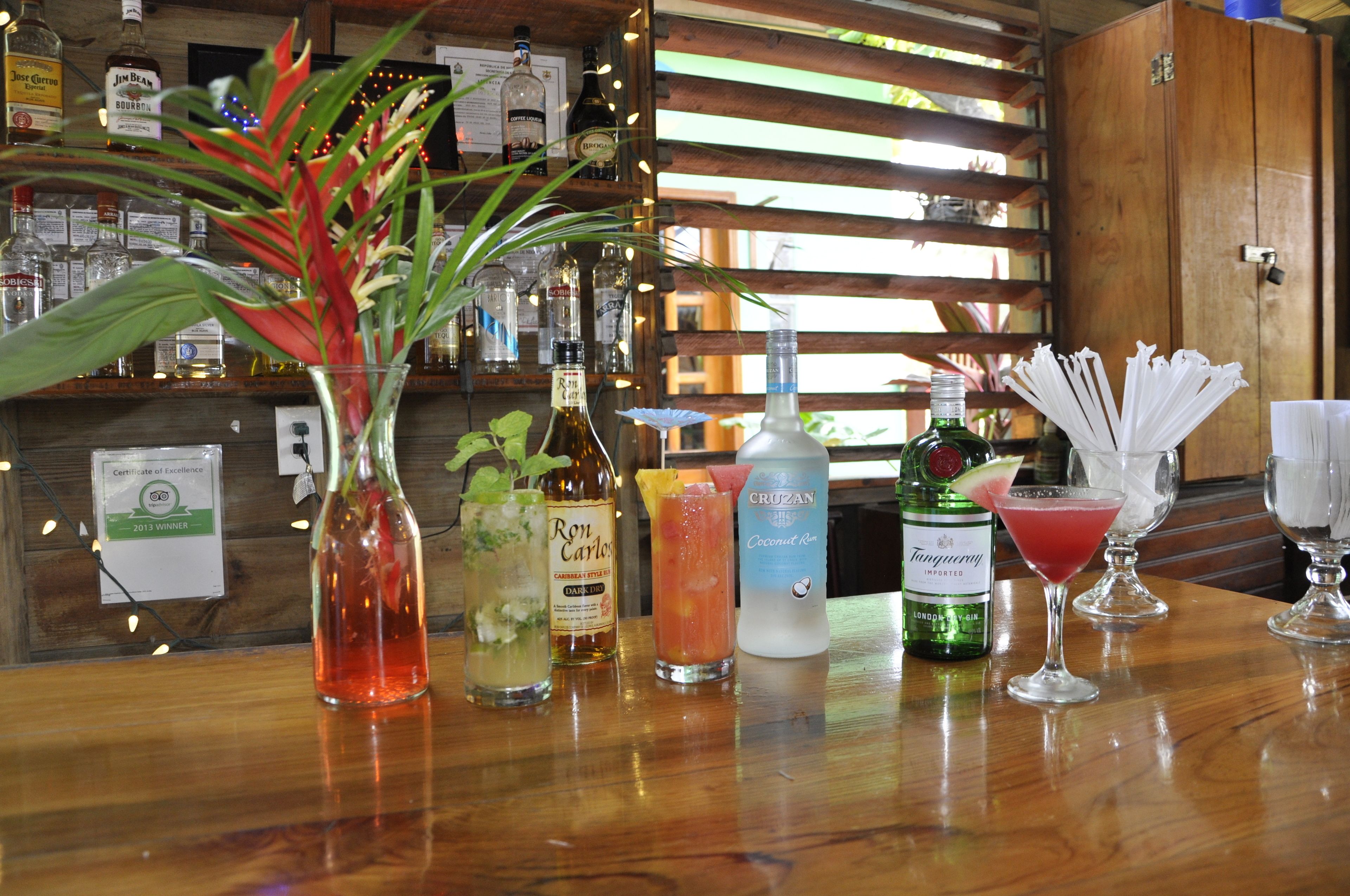 A bar area with various bottles and glasses, including a certificate of excellence on the wall.
