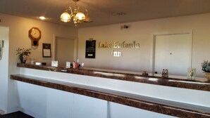 A hotel reception area with a marble counter, a clock, and a sign for Lake Eufaula Inn. - Lake Eufaula Inn (Checotah)