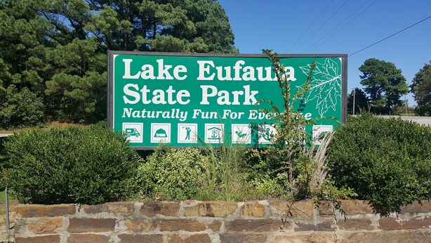 A sign for Lake Eufaula State Park with symbols indicating camping, RV parking, and picnic areas. - Lake Eufaula Inn (Checotah)