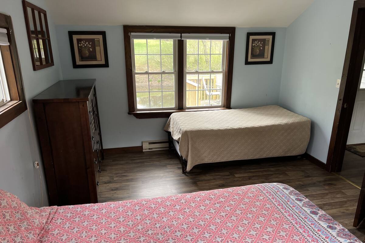 Un dormitorio con cama, cómoda y ventana.