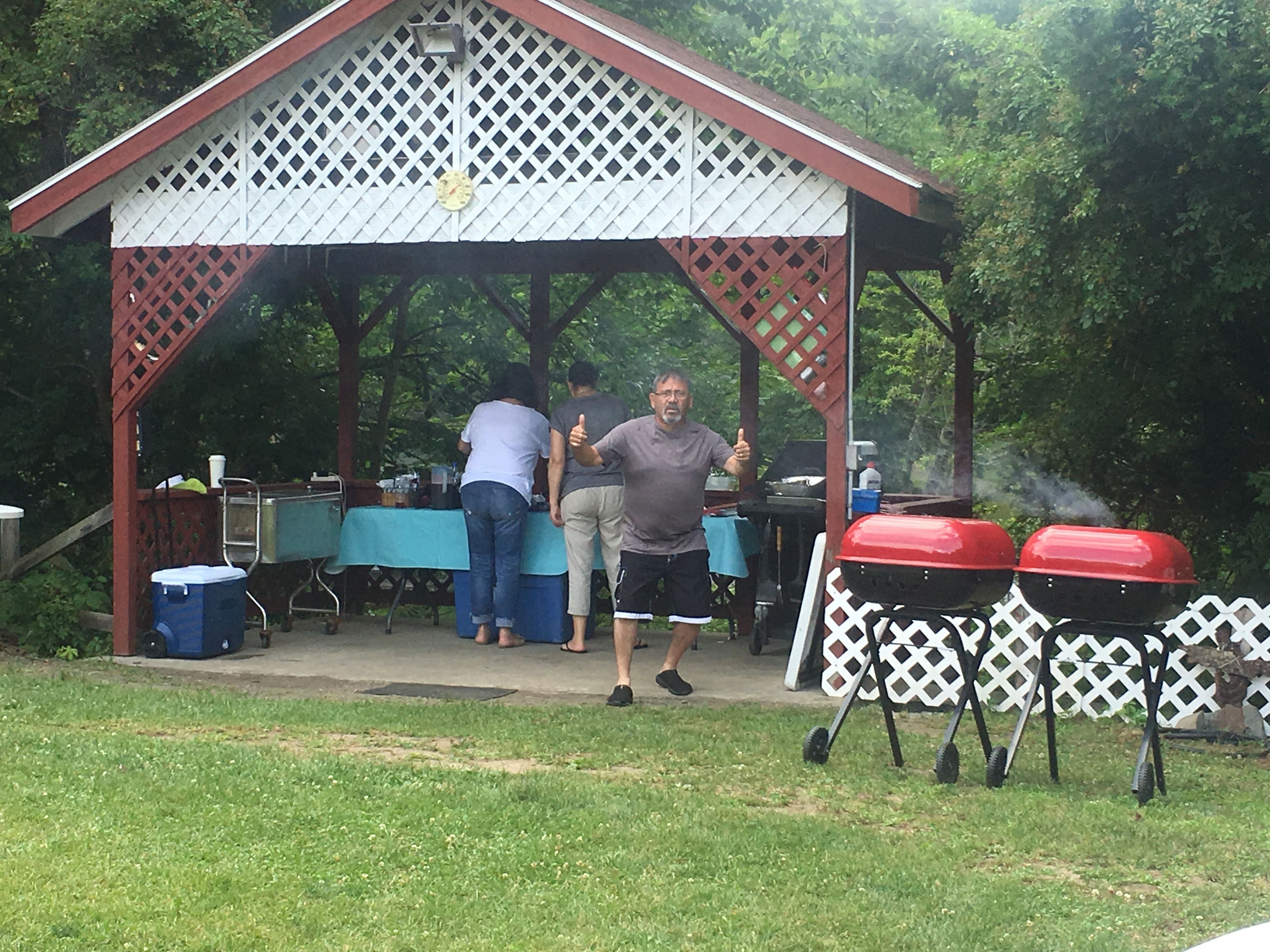 Un espace extérieur abrité, équipé d’un barbecue et d’une table pour les repas.