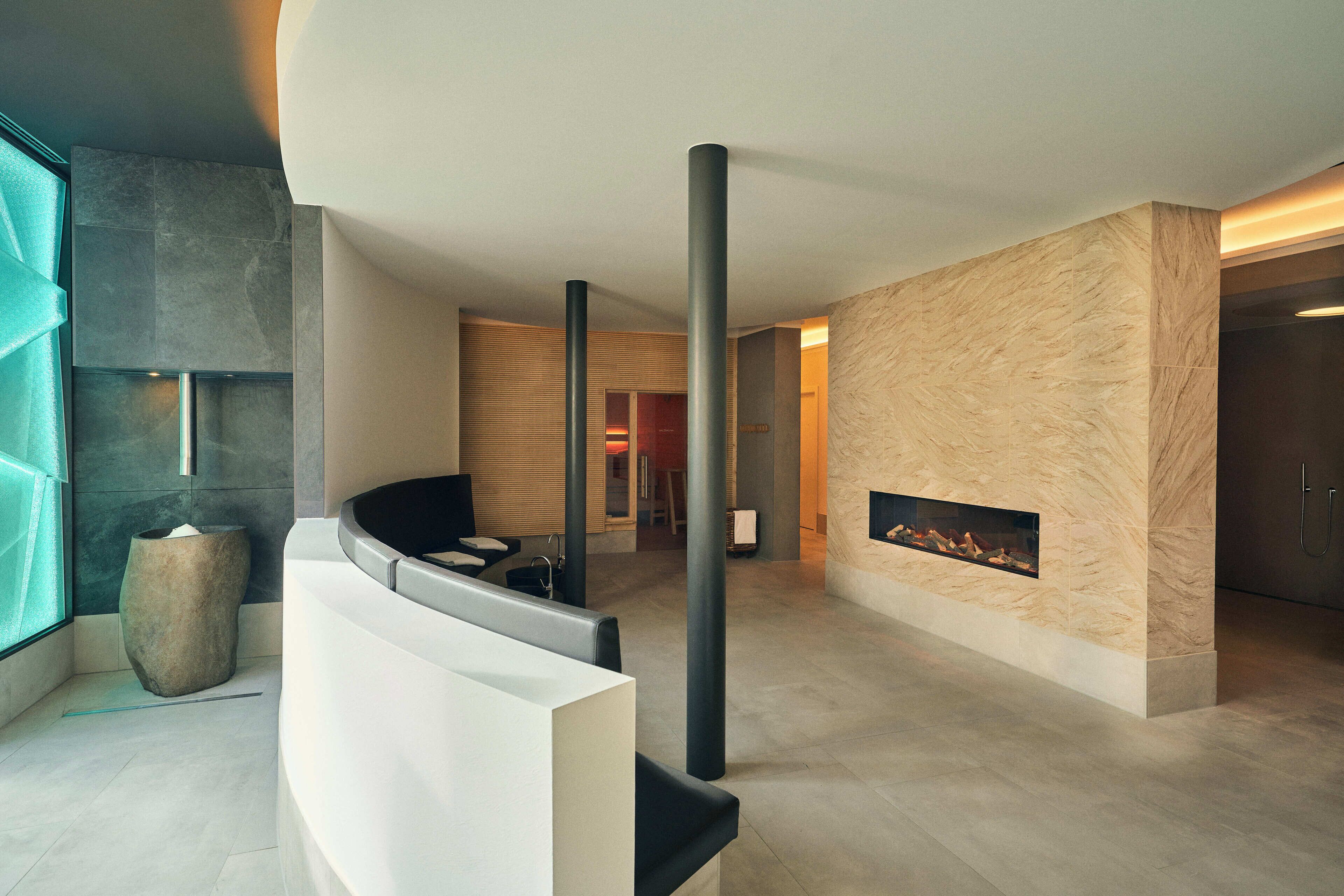A modern lobby with a fireplace, seating area, and a large window.