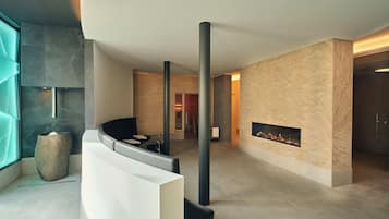 A modern lobby with a fireplace, seating area, and a large window.
