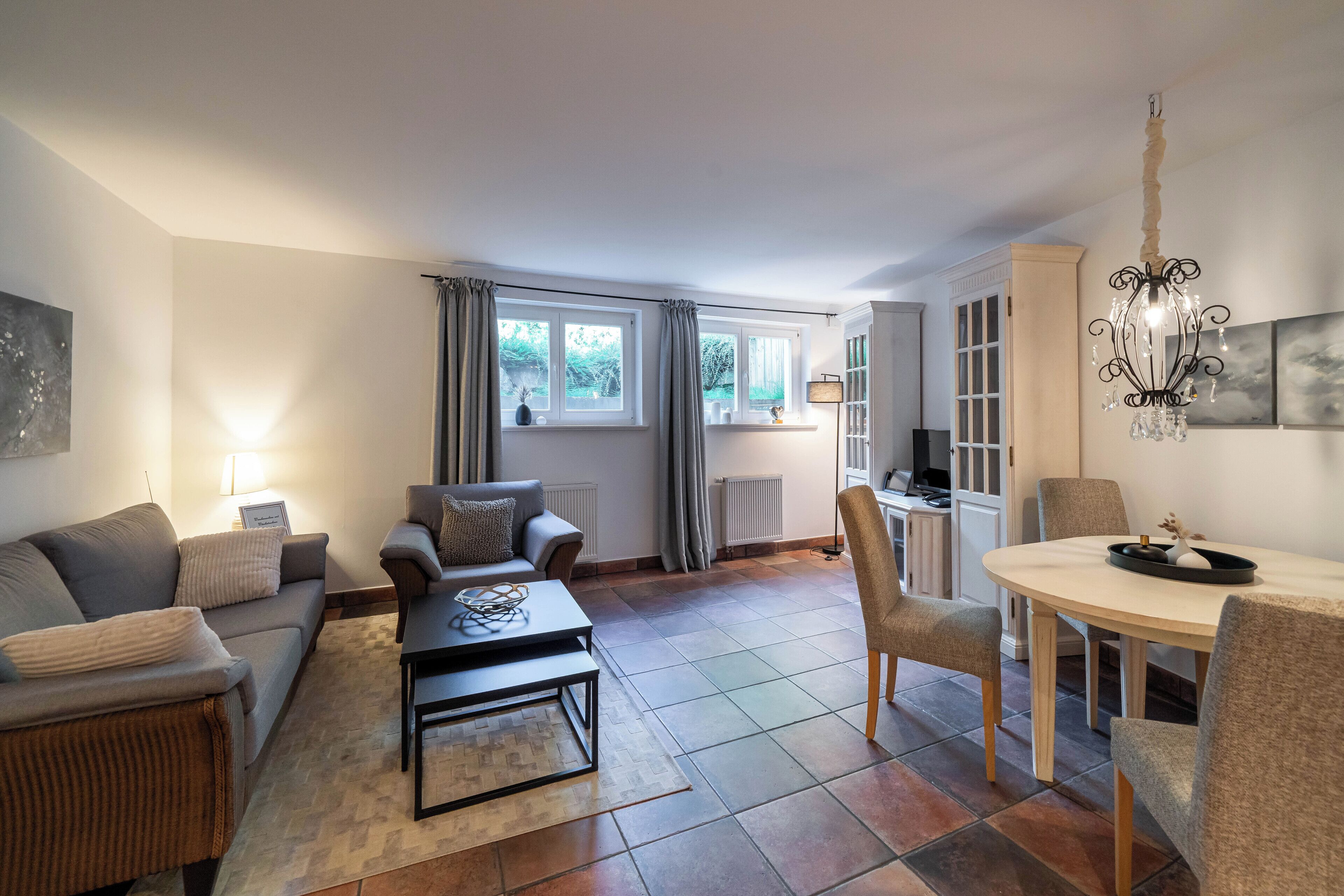 Ein modernes Wohnzimmer mit Sofa, Couchtisch und Essbereich.