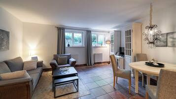 Ein modernes Wohnzimmer mit Sofa, Couchtisch und Essbereich.