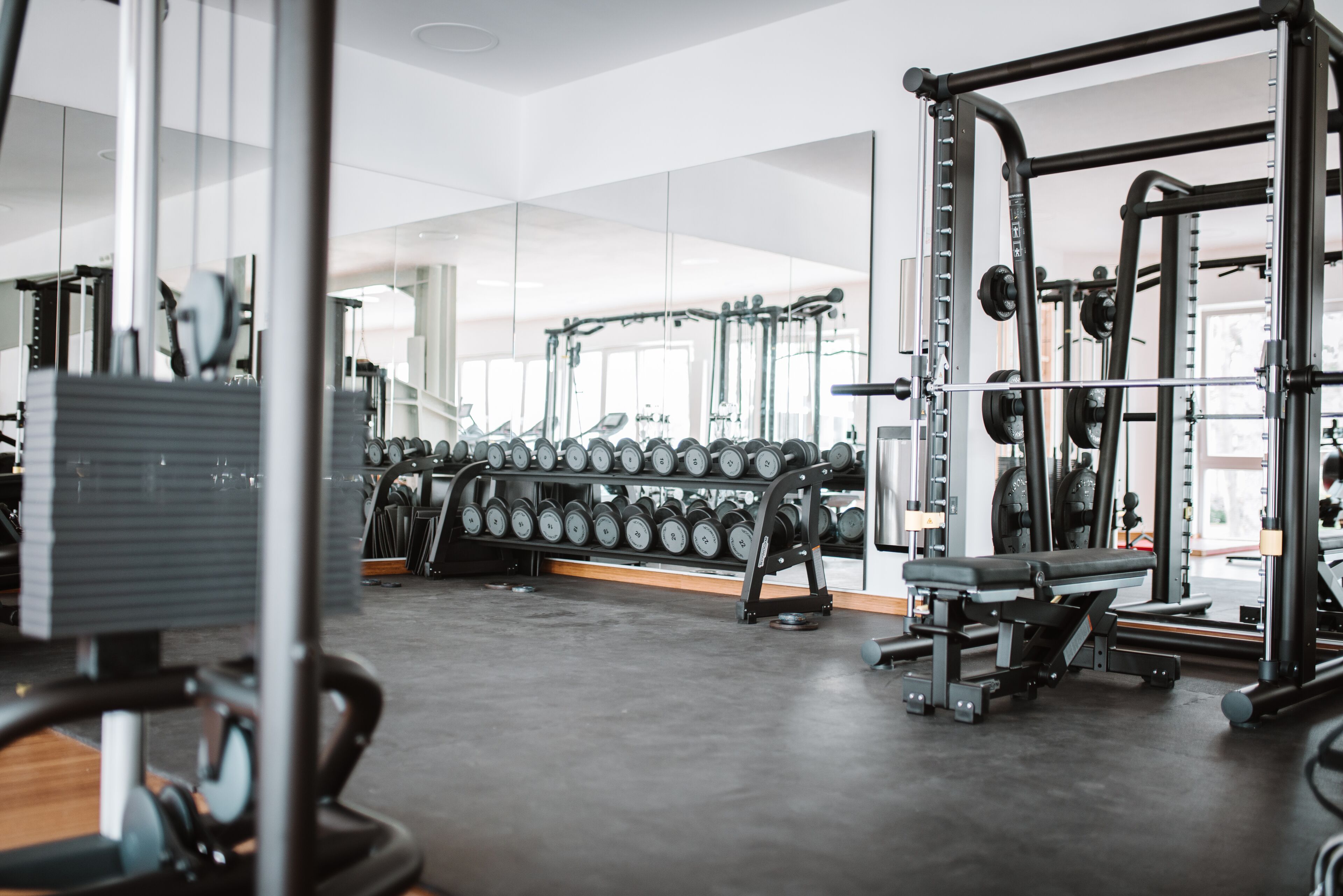 Ein Fitnessraum mit Krafttrainingsgeräten, Hanteln und Cardiogeräten.