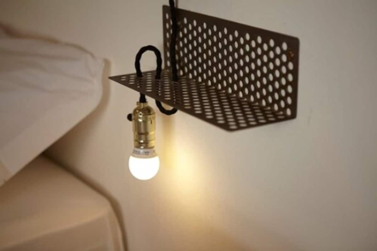 A wall-mounted metal shelf with a light bulb.