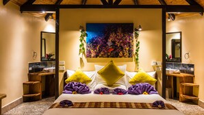 Ein Schlafzimmer mit einem großen Bett, zwei Nachttischen, einem Beistelltisch, einem Spiegel, einem Gemälde und einer Pflanze.