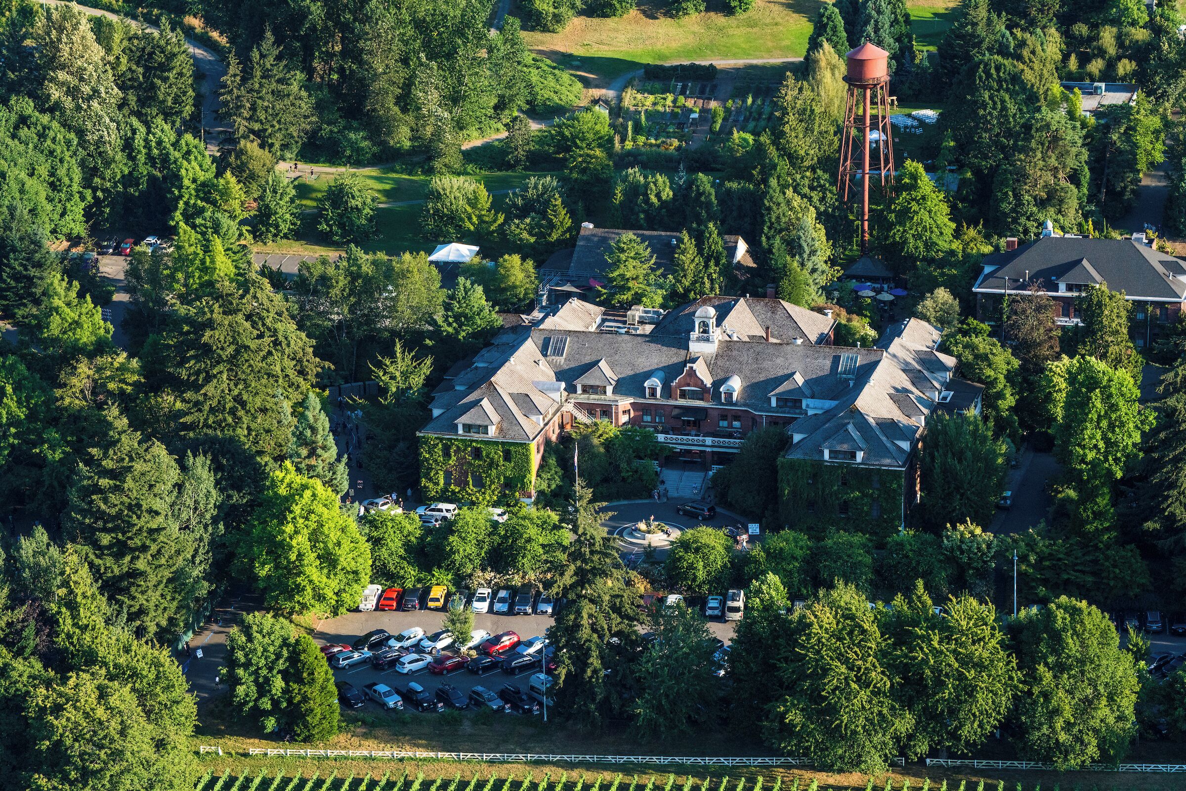 An aerial view of a residential area with houses, a parking lot, and a water tower.