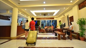 A hotel lobby with a reception desk, seating areas, and a large potted plant. - Villa de Sierra Vista (Puerto Princesa)