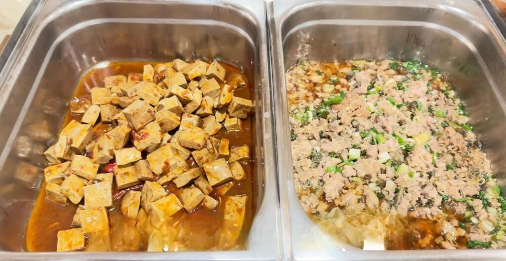 Two stainless steel food dispensers with tofu and ground meat dishes.