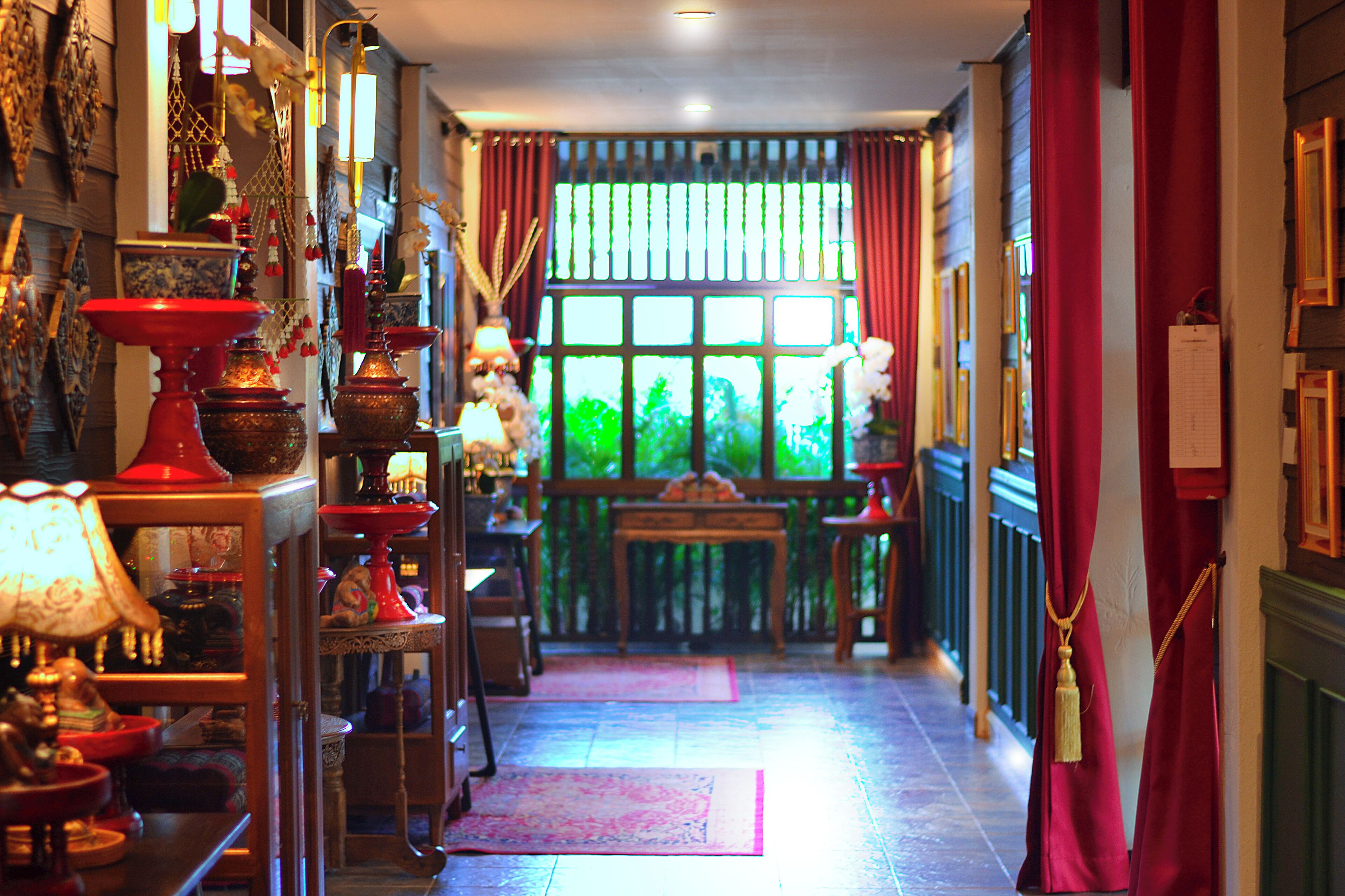 A hallway with a window, a wooden table, and various decorative items.