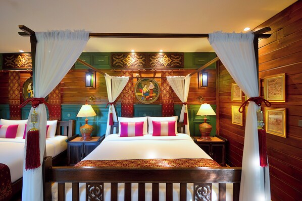 Una cama con dosel tapizada con sábanas blancas y almohadas rosas, cabecera de madera y un mural en la pared de atrás.