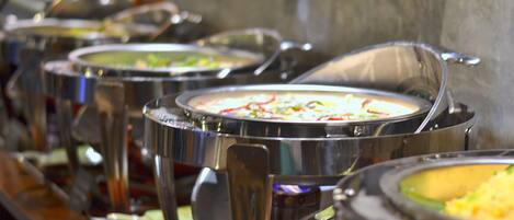 A buffet line with various dishes in metal serving containers.