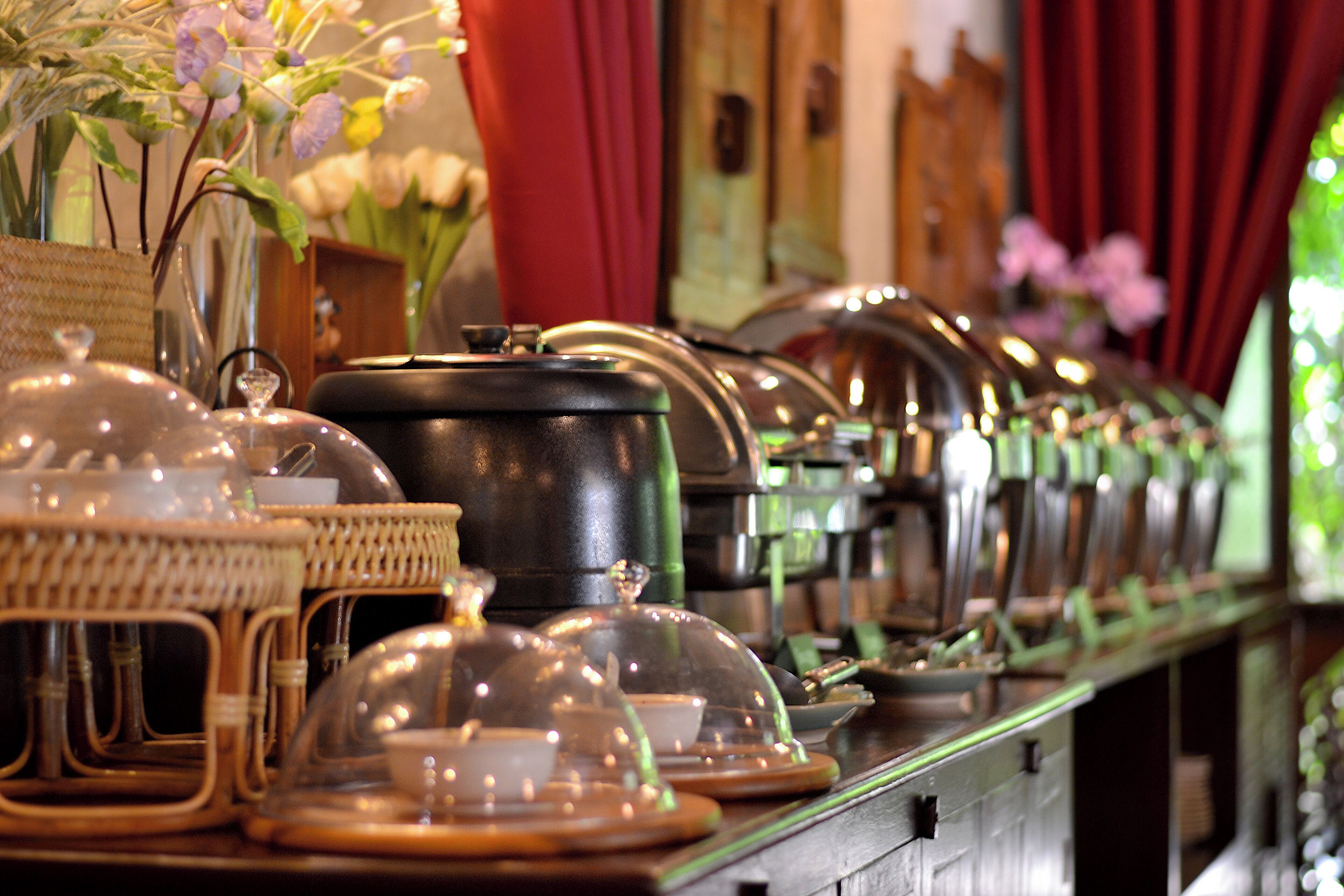 A buffet setup with covered dishes and a wicker basket.